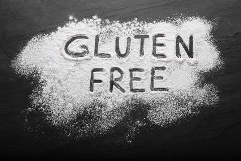 Phrase Gluten free written with flour on black table, top view Stock Photos