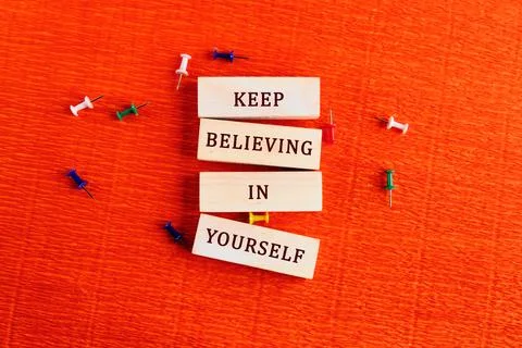 The phrase Keep Believing In Yourself is displayed on wooden blocks. Colorful Stock Photos