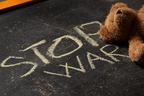 The phrase stop war is written on a black school board close-up and a brown c Stock Photos