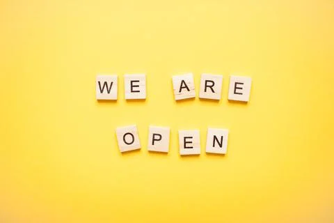 Phrase we are open made from wooden blocks on a light yellow background Stock Photos