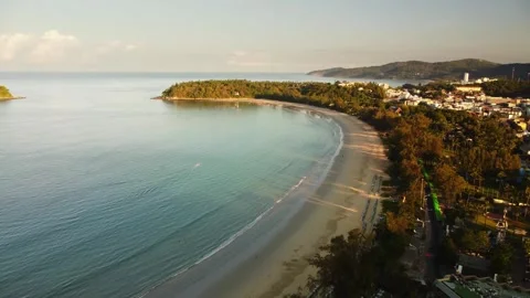 Phuket curved beach in aerial view at sunrise during golden light washes over Stock Footage 344086736