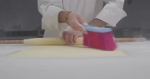 Phyllo dough preparation. Male chef roll out dough with a rolling pin, remove Stock Footage 287481630