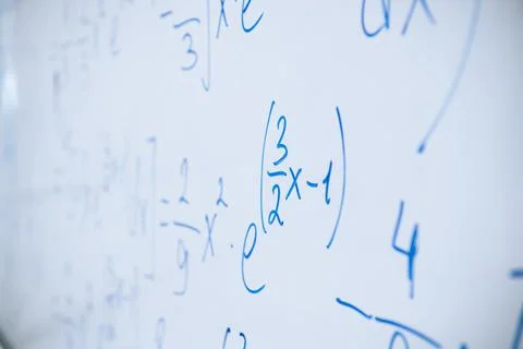 Physical and mathematical formulas written with a blue marker on a white board Stock Photos