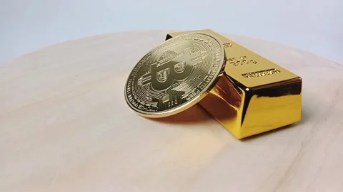 Physical Bitcoin coins stacked on top of gold bars on a wooden base Stock Footage 329081028