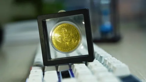 Physical bitcoin on keyboard in display cube, Close-up of a physical bitcoi.. Stock-Footage 329176972