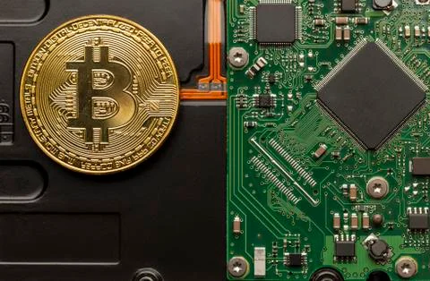 Physical bitcoin on top of a circuit board. Stock Photos