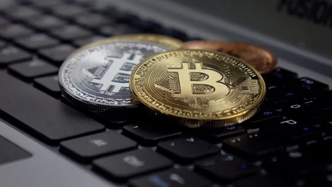 Physical metal Bitcoins on computer keyboard, CU rotation Stock Footage 83382678