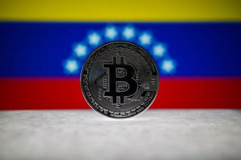 Physical silver version of Bitcoin (BTC) and Venezuela Flag on the background Stock Photos