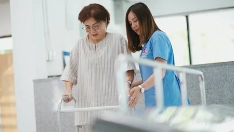  physical therapist helping  patient in using walker during  rehabilitation Stock Footage 130812847