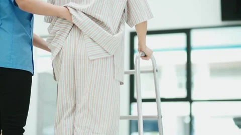  physical therapist helping  patient in using walker during  rehabilitation Stock Footage 130812896