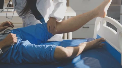 Physical therapist performing ankle examination on patient in clinic Stock Footage 343708019