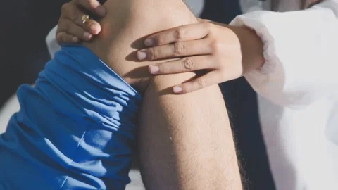 Physical therapist performing ankle examination on patient in clinic Stock Footage 343708080