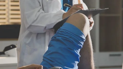 Physical therapist performing ankle examination on patient in clinic Stock Footage 343708266