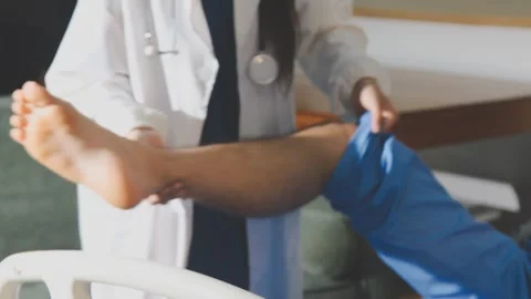 Physical therapist performing ankle examination on patient in clinic Stock Footage 343708546