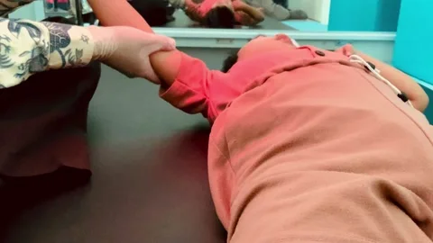 Physical therapist performing passive range of motion exercise on childs arm Stock Footage 333299435