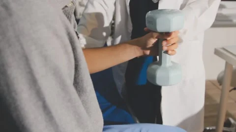 Physical therapist performs shoulder range of motion test on male patient Stock Footage 343708755