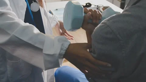 Physical therapist performs shoulder range of motion test on male patient Stock Footage 343708802