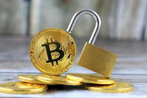 Physical version of Bitcoin (new virtual money) and golden padlock. Concept.. Stock Photos