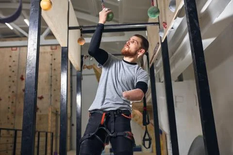 Physically challenged boulderer fixing special equipment at chin-up bar Stock Photos