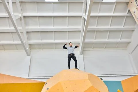 Physically challenged boulderer standing at the top of artificial climbing wall Stock Photos