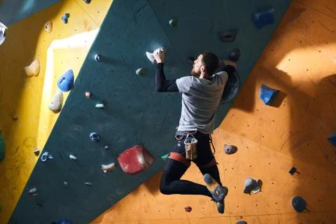 Physically challenged man practising new extreme hobby in bouldering gym Stock Photos