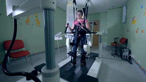 Physically challenged young girl is going through a walking practice with the 動画素材 98642227