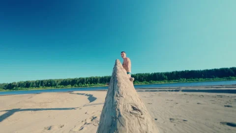 A physically developed man puts a log on his shoulder and carries it. Stock Footage 313496871