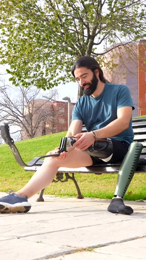 Physically disabled man adjusting prosthetic leg before running Stock Footage 260558557
