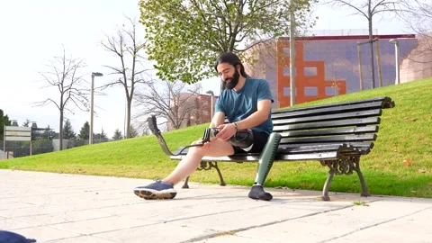 Physically disabled man adjusting prosthetic leg before running Stock Footage 260559216