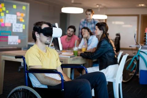 Physically disabled man on wheelchair using VR headset Stock Photos