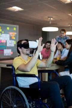 Physically disabled man on wheelchair using VR headset Stock Photos