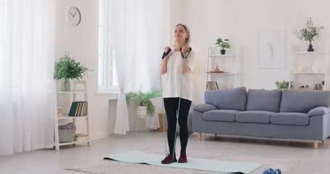 Physically fit and healthy senior woman exercising with an elastic fitness band Stock Footage 320277631