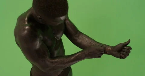 Physically fit athlete male model covered in black tearing at his skin 스톡 동영상 104328896