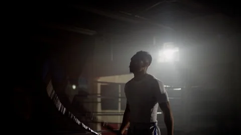 Physically fit Muay Thai fighter skipping in gym beside boxing ring 스톡 동영상 104578878