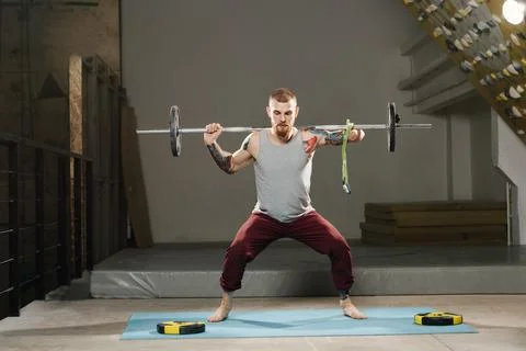 Physically strong disabled armless man training in the gym. Tackling barbell Stock Photos