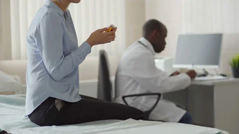 Physician and patient with pills in doctors office Stock Footage