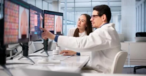 Physician And Team Using Dermatoscope For Melanoma Detection Training. Stock Photos