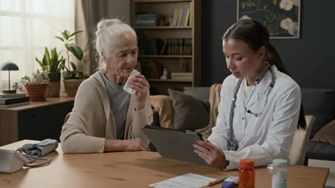 Physician Asking Senior Patient about Health Problems and Taking Notes on Tablet Stock Footage 329180177