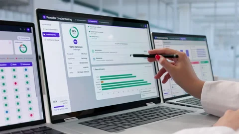 Physician Assistant Reviews Credentialing Data On Multiple Screens Stock Footage 339171141