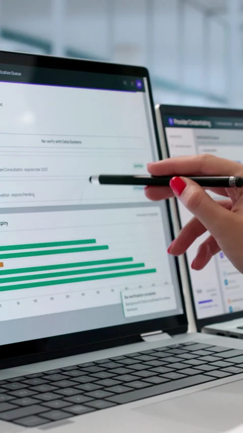 Physician Assistant Reviews Credentialing Data On Multiple Screens Stock Footage 339902620