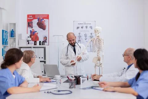 Physician doctor with stethoscope discussing bone structure using human skeleton Stock Photos