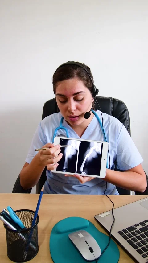 Physician looking at x ray scan results on tablet, explaining bones exam to f Stock Footage 203788541