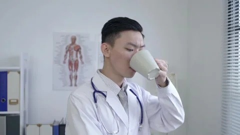 Physician is sipping tea while looking outside Video stock 154445846
