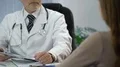 Physician talking to patient and checking medical records on his tablet PC HD Footage