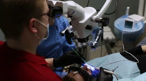 The physician treating the teeth with a microscope Video stock 58552654