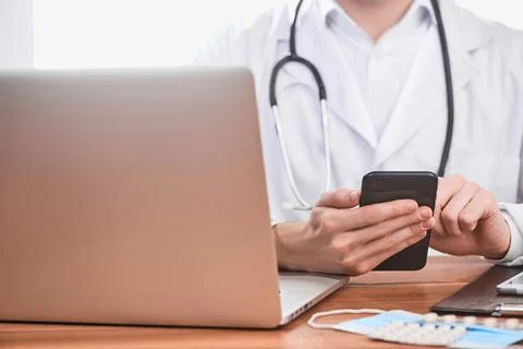 Physician using a cell phone at work 写真素材