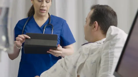 Physician using an ipad/tablet to give instructions to hospital patient 動画素材 62534124