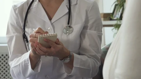 Physician writes complaints of elder lady in small notebook Stock Footage 111059614
