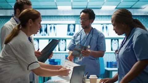 Physicians and radiologists analyzing x ray scans to create treatment plan Stock Footage 282621447
