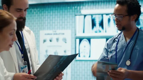 Physicians and radiologists analyzing x ray scans to create treatment plan Stock Footage 282679349